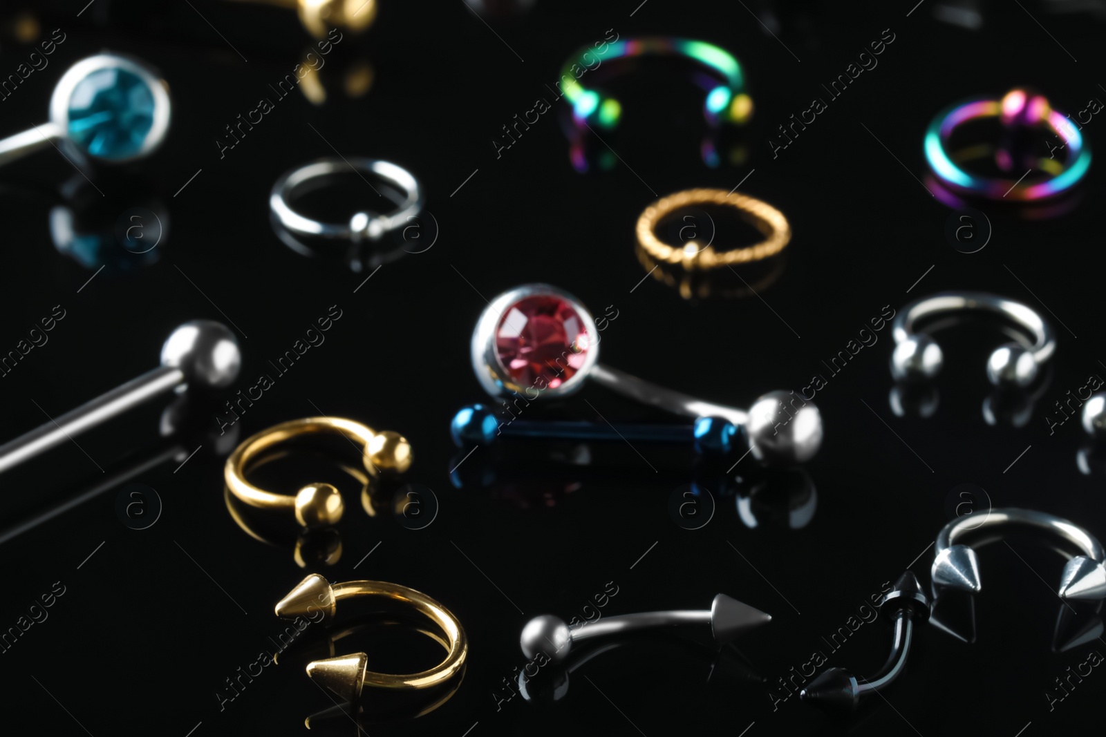 Photo of Stylish jewelry for piercing on black background