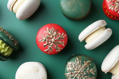 Photo of Beautifully decorated Christmas macarons on green background, flat lay