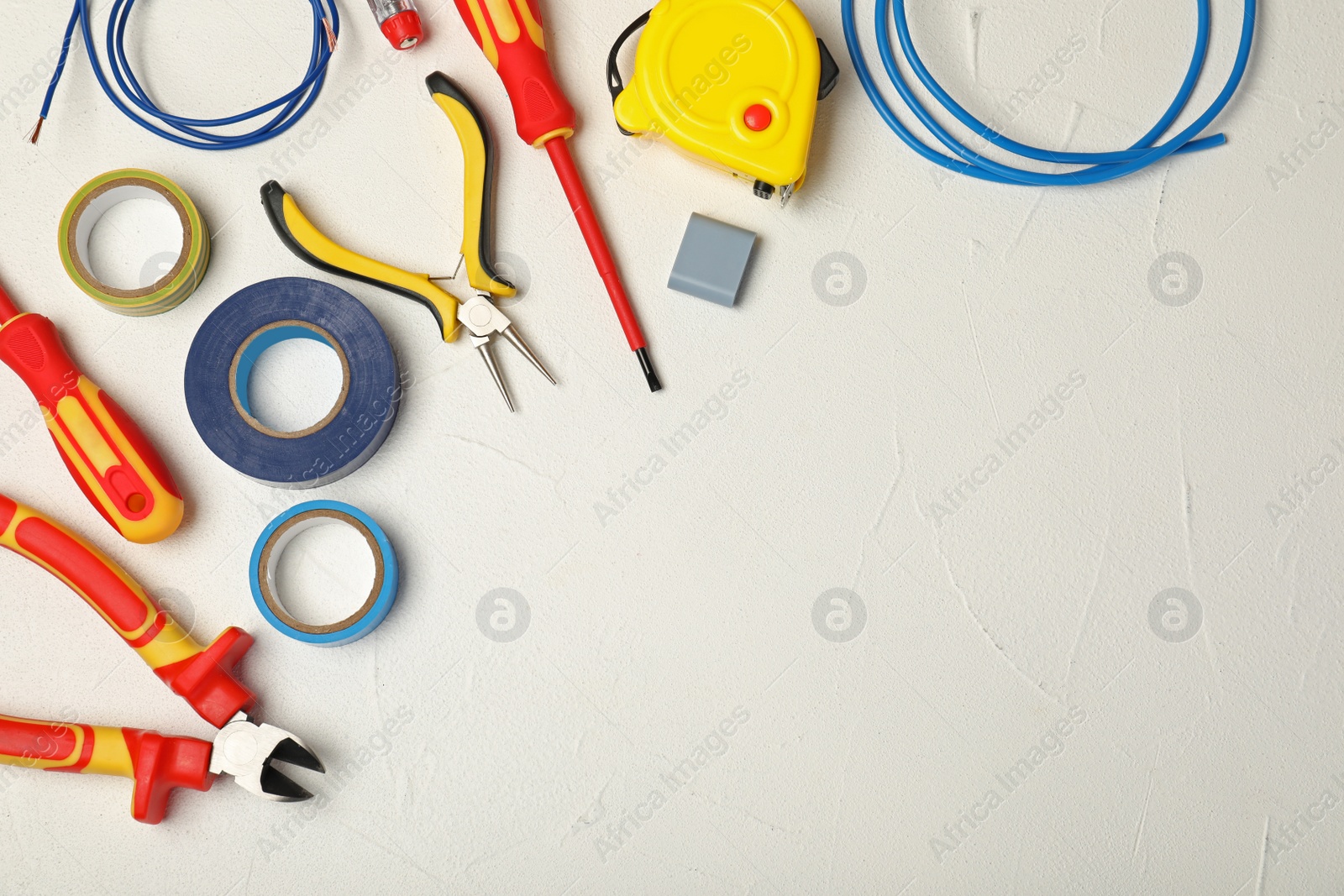 Photo of Flat lay composition with electrician's tools and space for text on light background