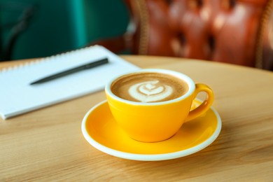 Photo of Cup of delicious coffee on wooden table indoors