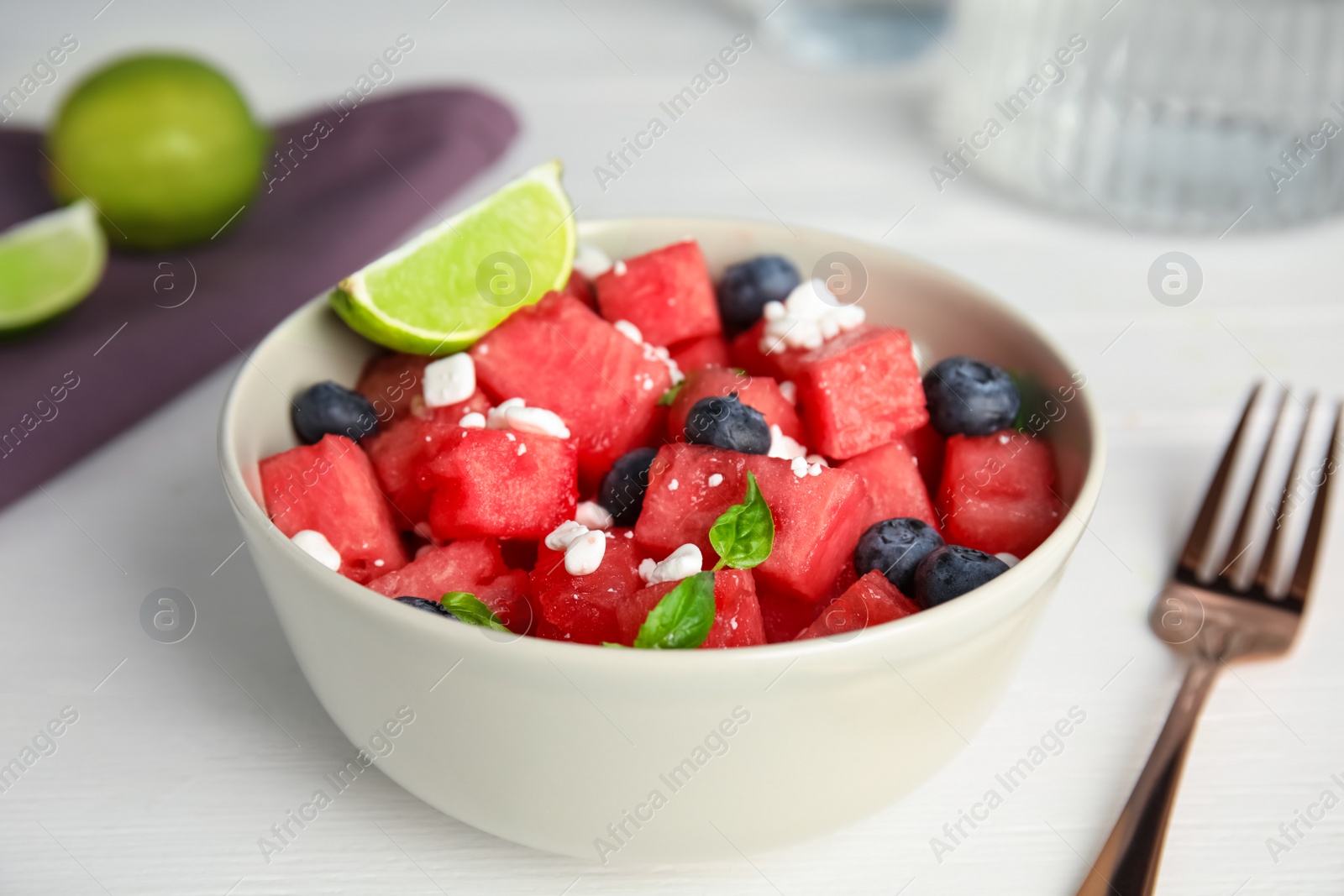 Photo of Delicious salad with watermelon, blueberries and cheese on white table, closeup