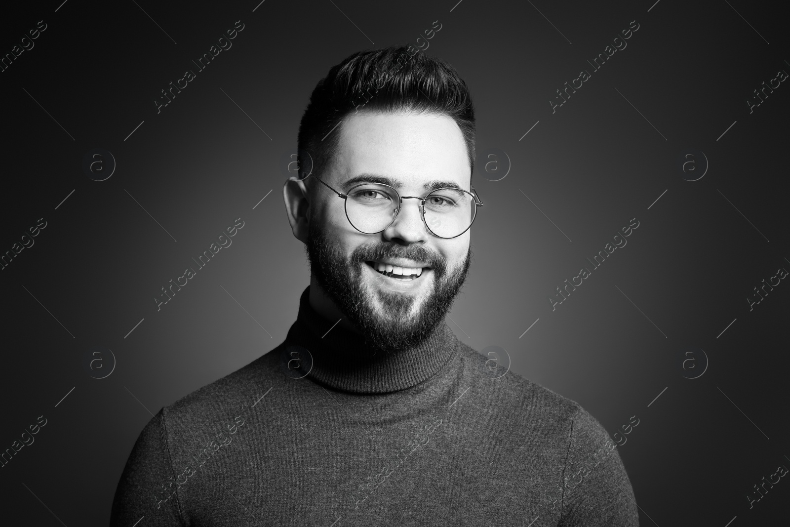 Photo of Portrait of handsome bearded man on dark background. Black and white effect