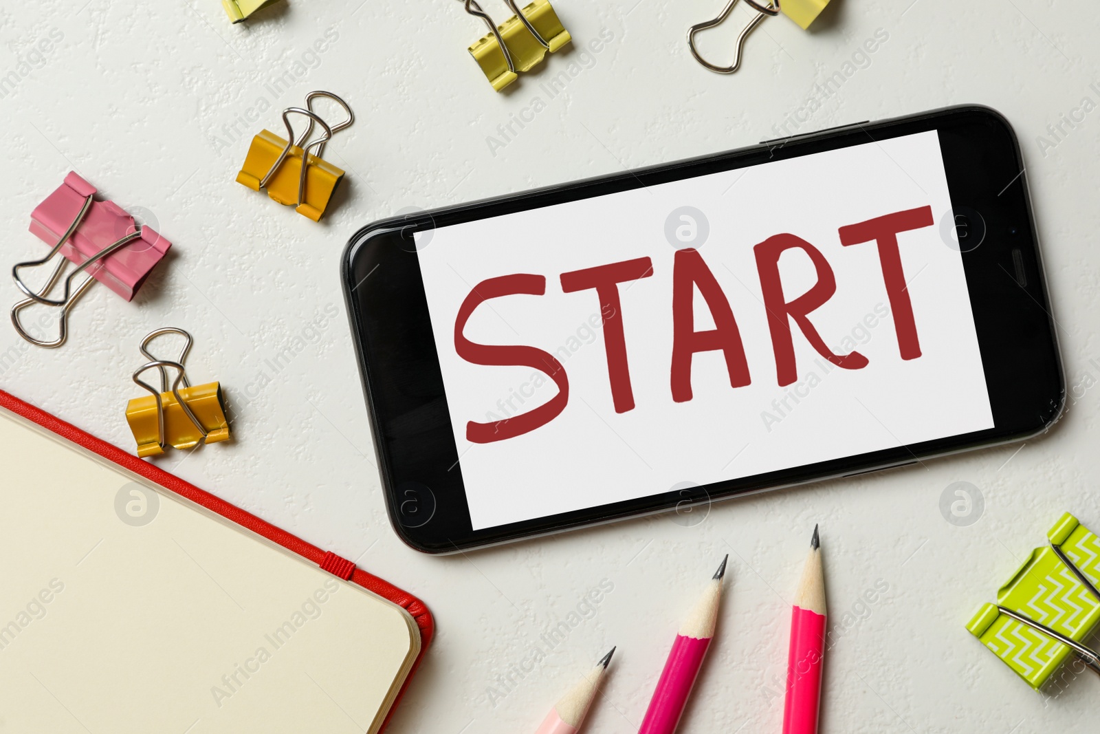 Photo of Smartphone with word Start and stationery on white background, flat lay