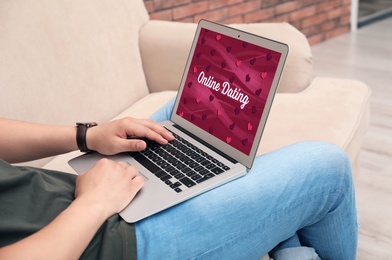 Man visiting dating site via laptop indoors, closeup