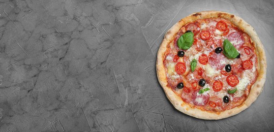 Delicious pizza Diablo on grey table, top view with space for text. Banner design