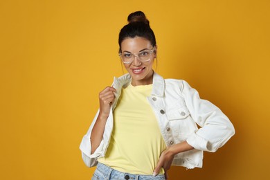 Photo of Beautiful woman in eyeglasses on yellow background