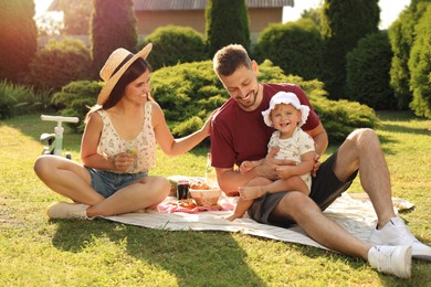 Photo of Happy family having picnic in garden on sunny day