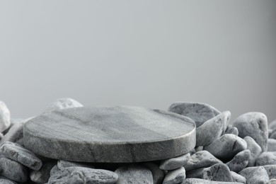 Photo of Presentation for product. Stone and pebbles on grey background. Space for text