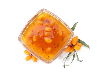 Delicious sea buckthorn jam in bowl and fresh berries on white background, top view