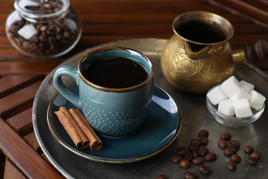 Photo of Turkish coffee. Freshly brewed beverage served on wooden table, closeup