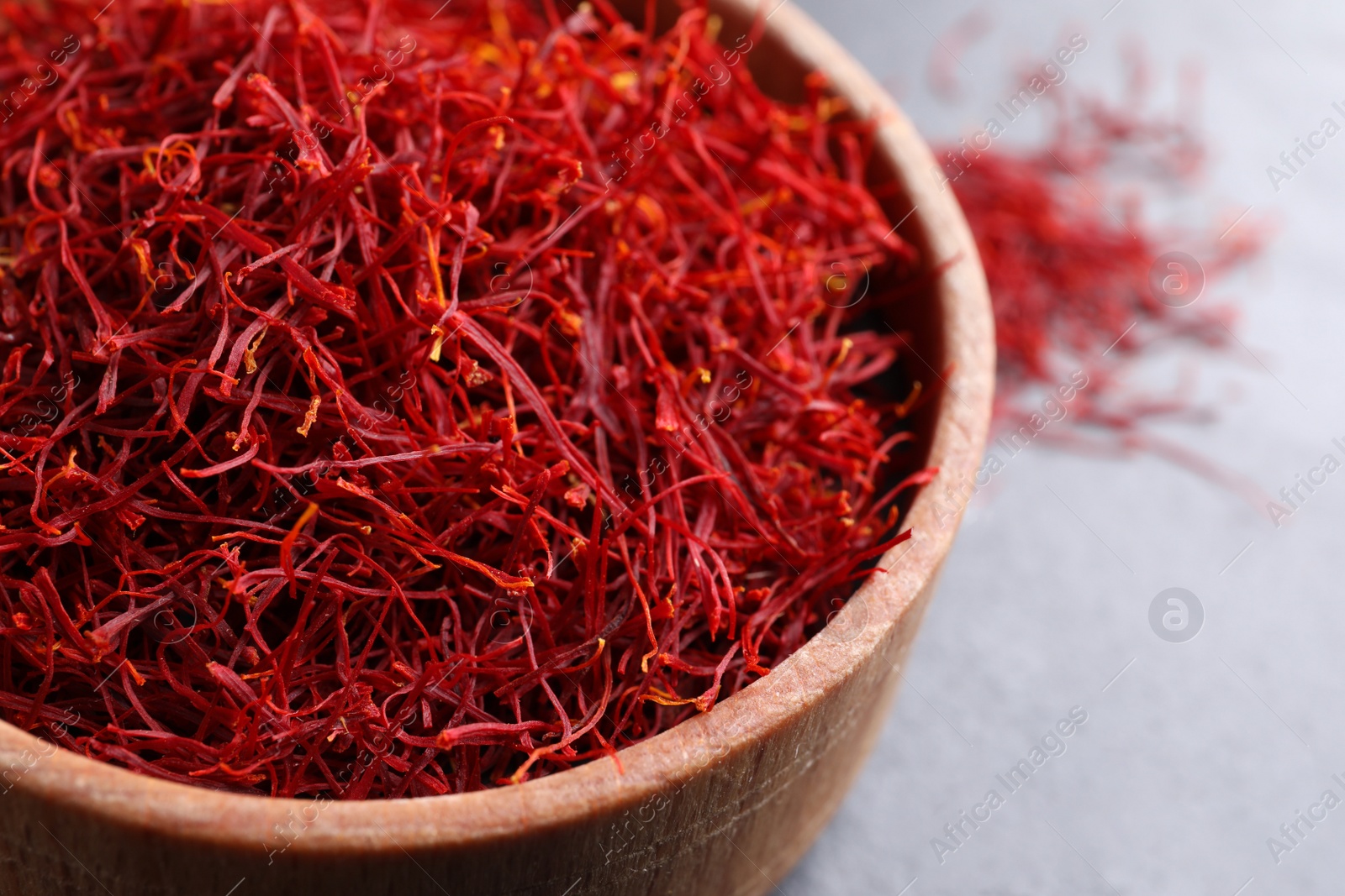 Photo of Dried saffron in bowl on table, closeup