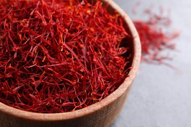 Photo of Dried saffron in bowl on table, closeup