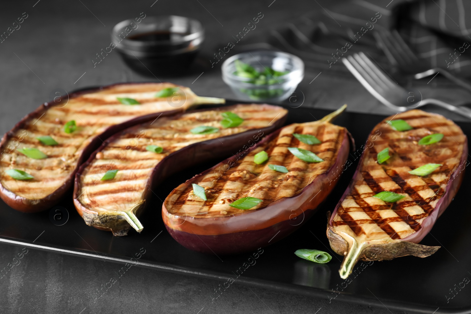 Photo of Delicious grilled eggplant halves served on plate, closeup