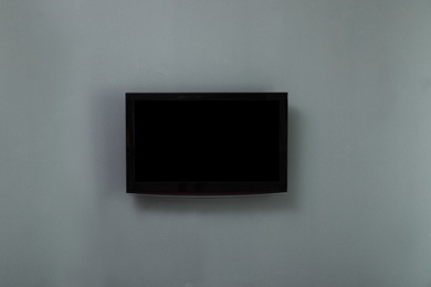 Photo of New modern plasma TV on color background. Space for design