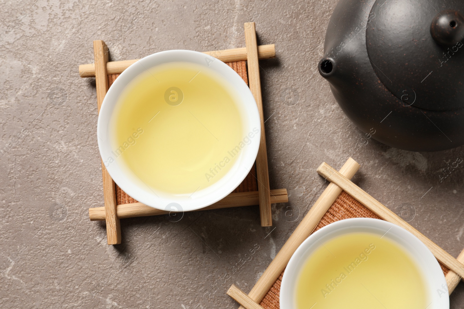 Photo of Cups and teapot of Tie Guan Yin oolong on table, top view