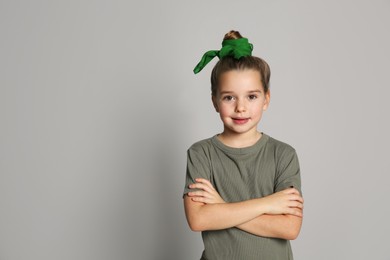 Photo of Cute little girl with stylish bandana on grey background, space for text
