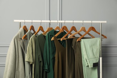 Photo of Rack with different stylish women`s clothes near grey wall