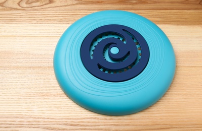 Photo of Blue plastic frisbee disk on wooden background