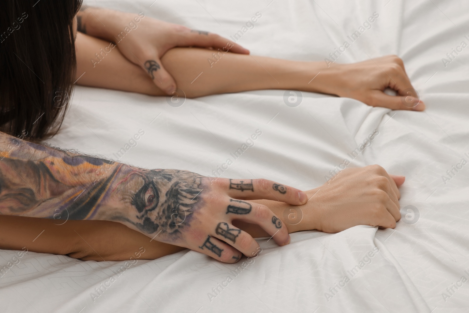 Photo of Passionate couple having sex on bed, closeup of hands