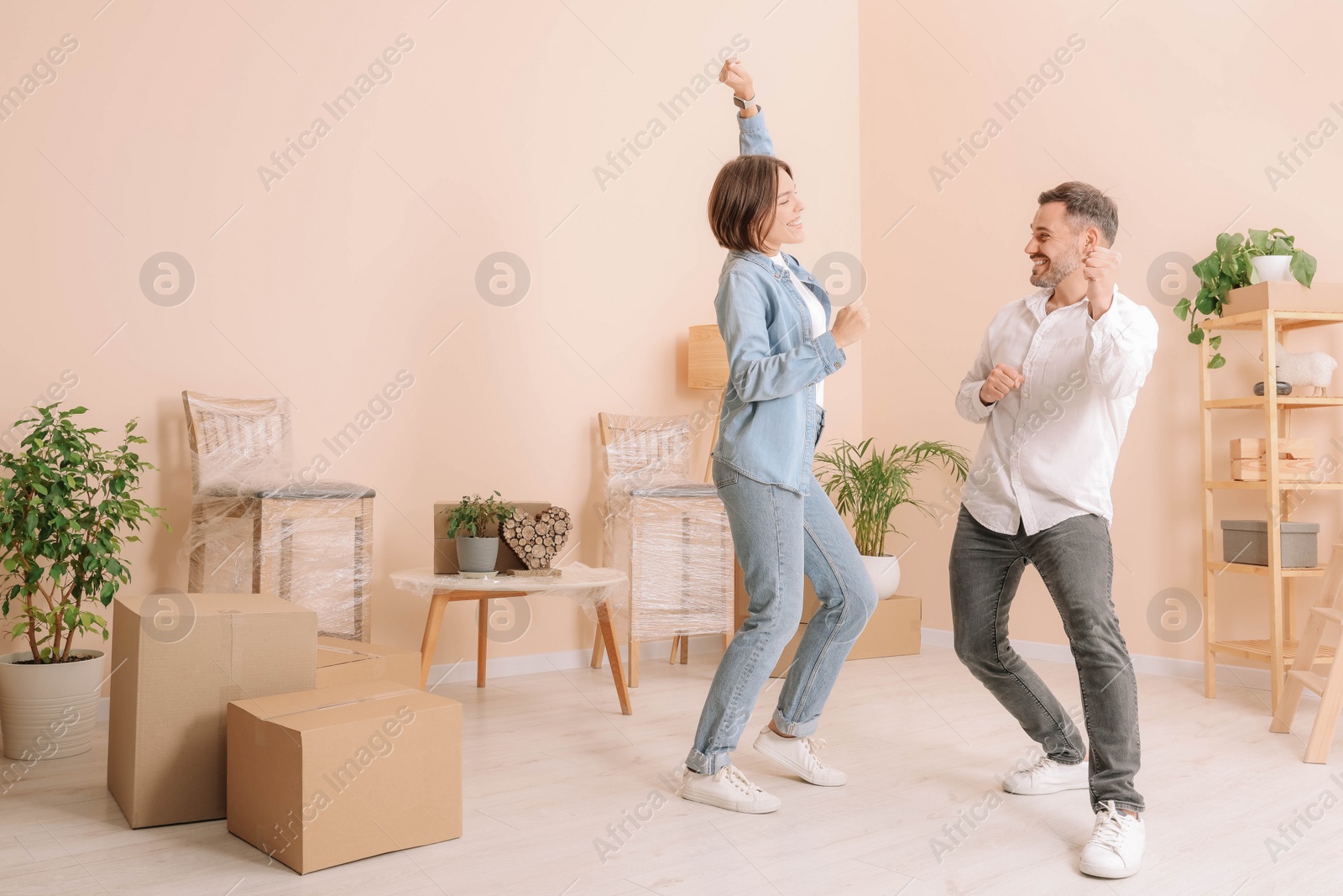 Photo of Happy couple having fun in new apartment. Moving day