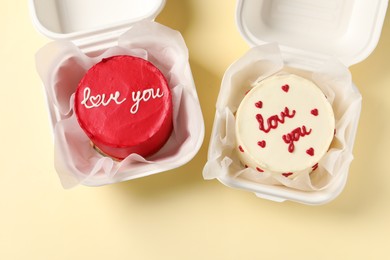 Photo of Bento cakes in takeaway boxes on beige table, flat lay. St. Valentine's day surprise