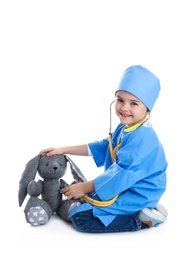 Cute child playing doctor with stuffed toy on white background