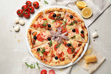 Photo of Tasty pizza with seafood and ingredients on light grey marble table, flat lay