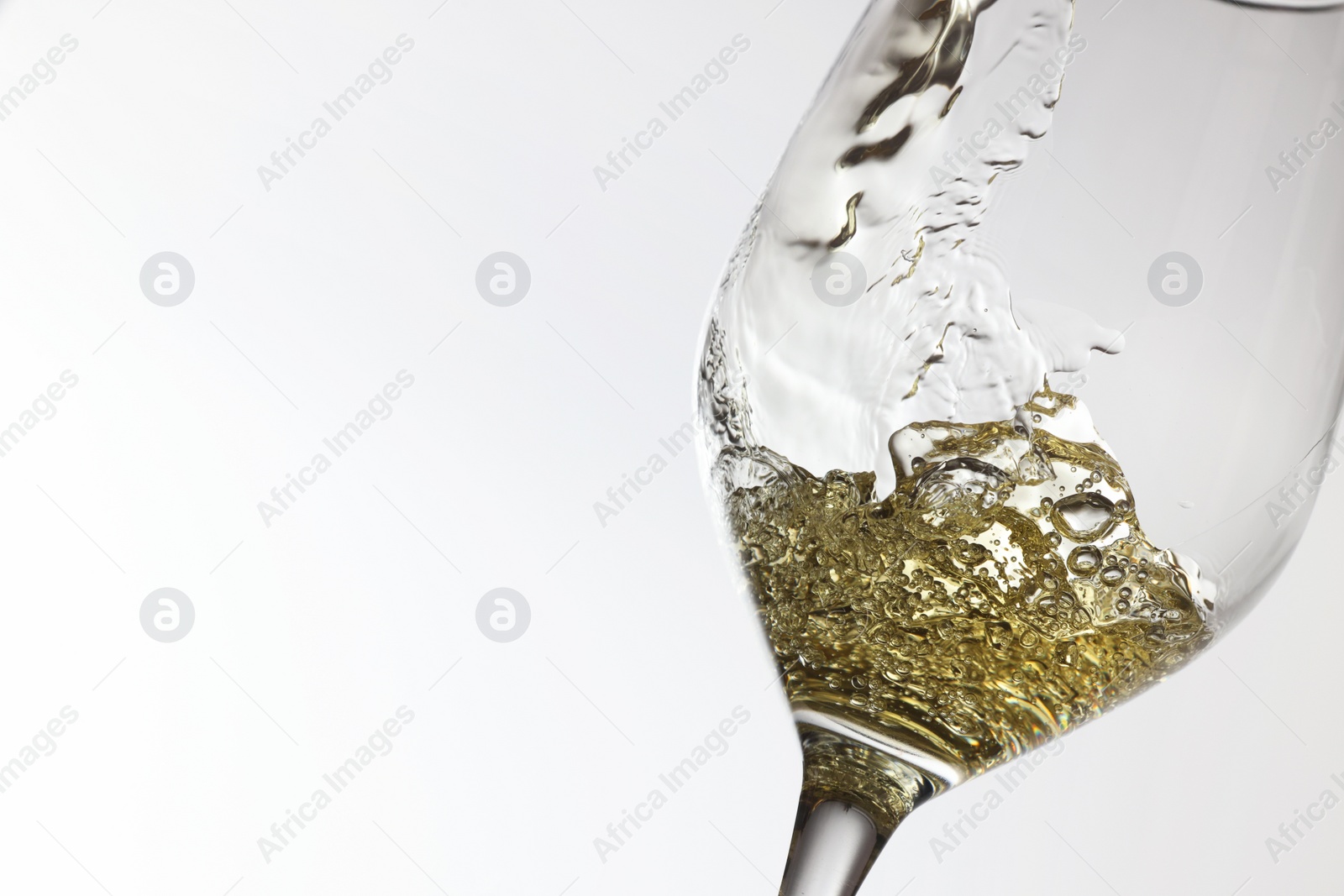 Photo of Tasty aromatic wine in glass on white background, closeup. Space for text