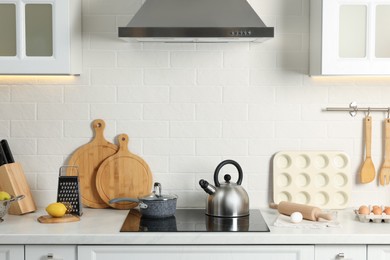 Photo of Countertop with stove, products and cooking utensils in kitchen