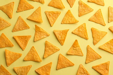 Photo of Flat lay composition of tortilla chips (nachos) on yellow background