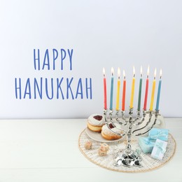 Image of Happy Hanukkah. Menorah, donuts, dreidels and gifts on white table