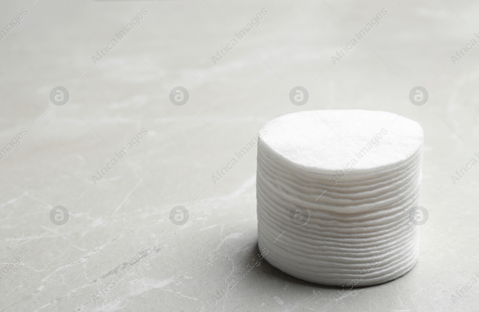 Photo of Stack of cotton pads on grey background. Space for text