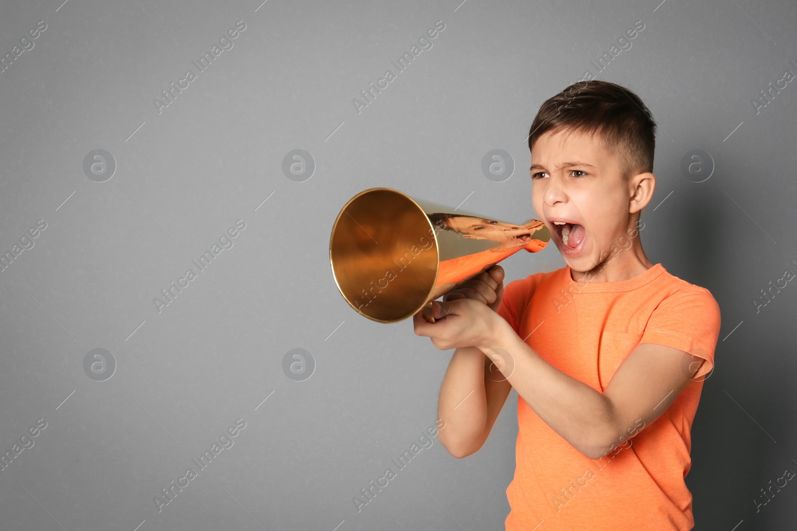 Photo of Cute little boy with megaphone on grey background