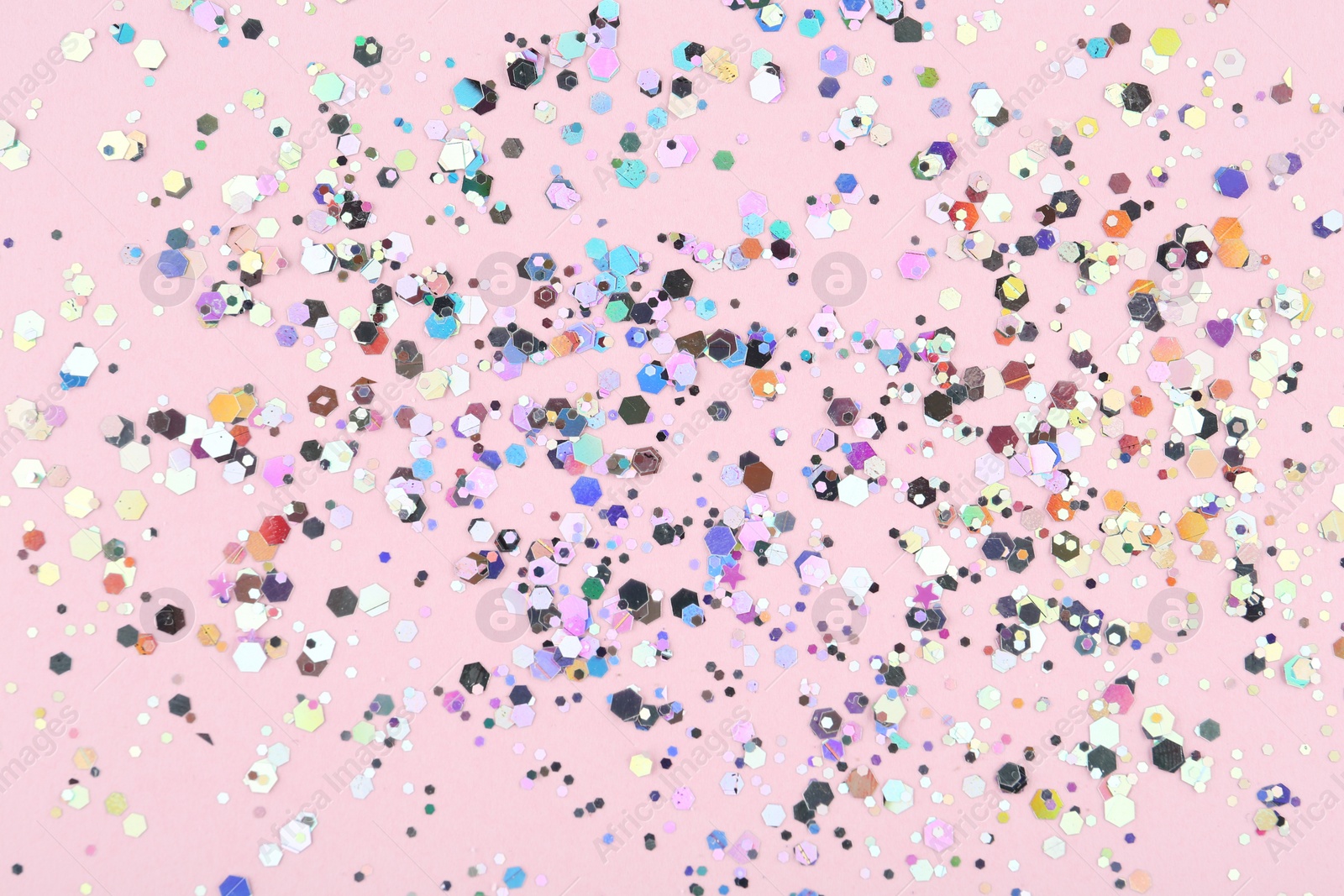 Photo of Shiny glitter on light pink background, top view