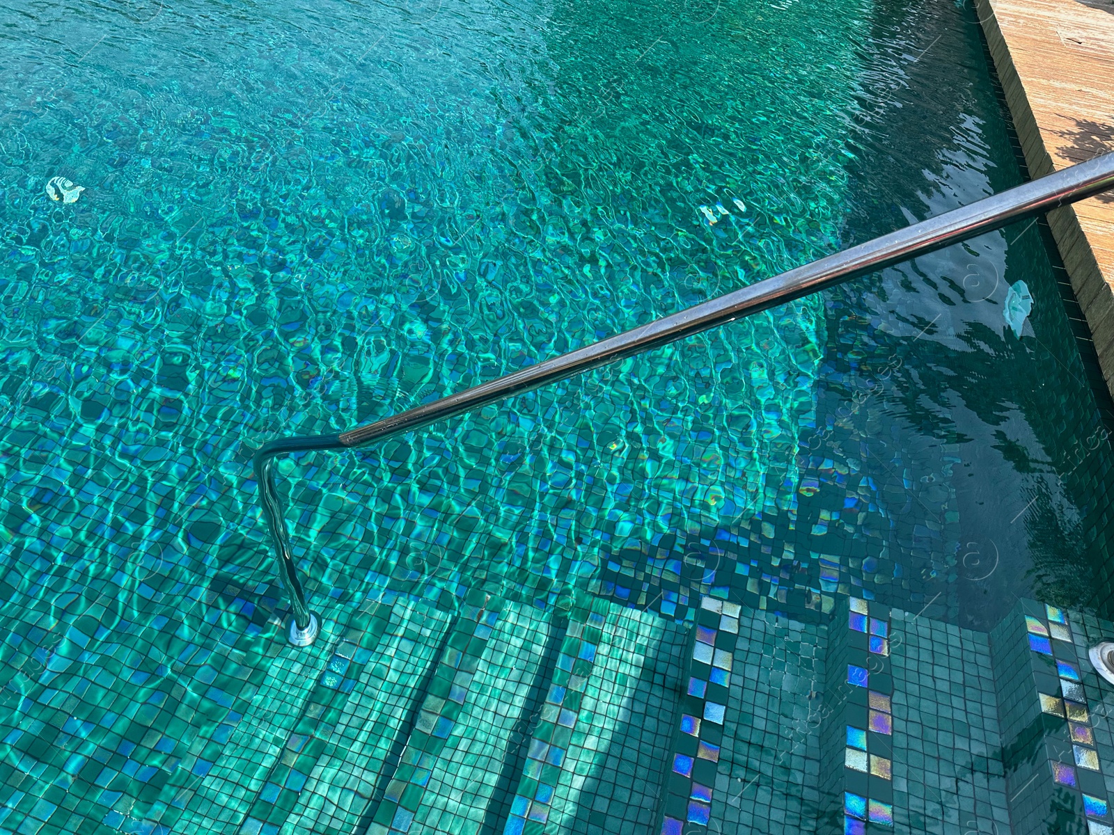 Photo of Metal rail and steps in outdoor swimming pool