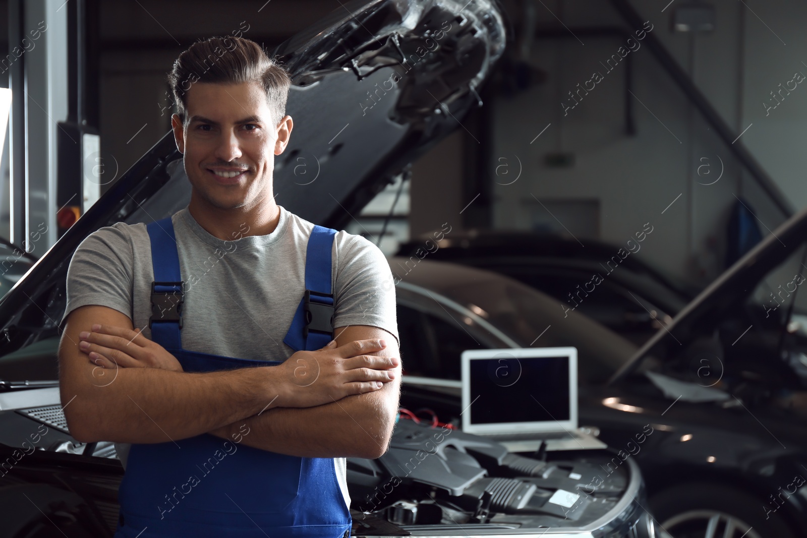 Photo of Mechanic near automobile in service center, space for text. Car diagnostic