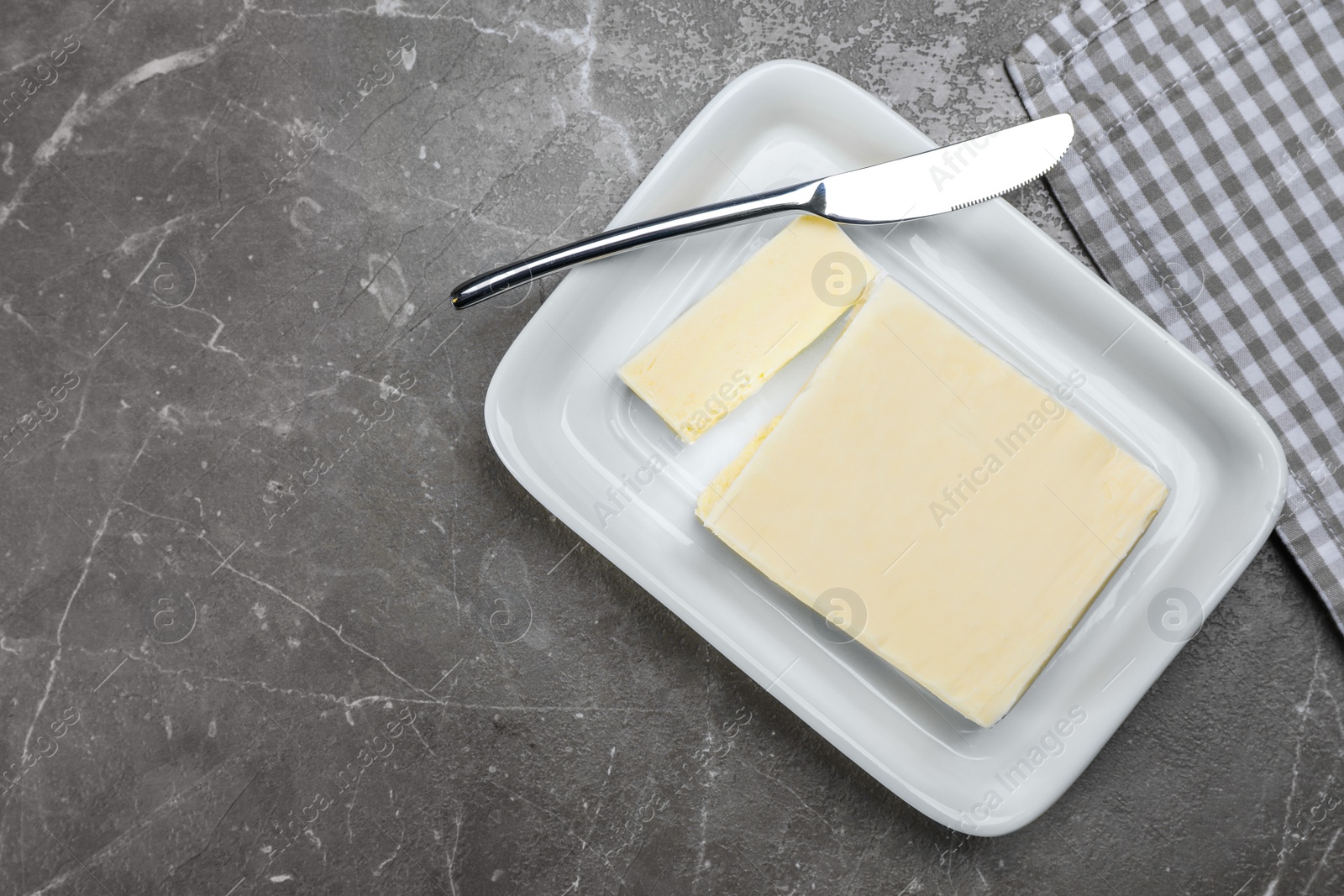 Photo of Plate with tasty fresh butter and knife on table, top view