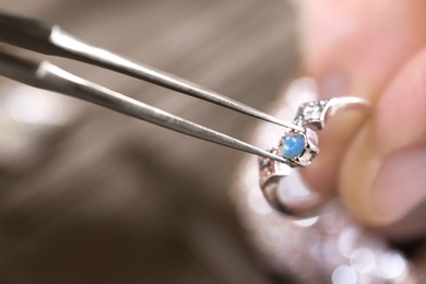 Photo of Male jeweler examining ring in workshop, closeup view