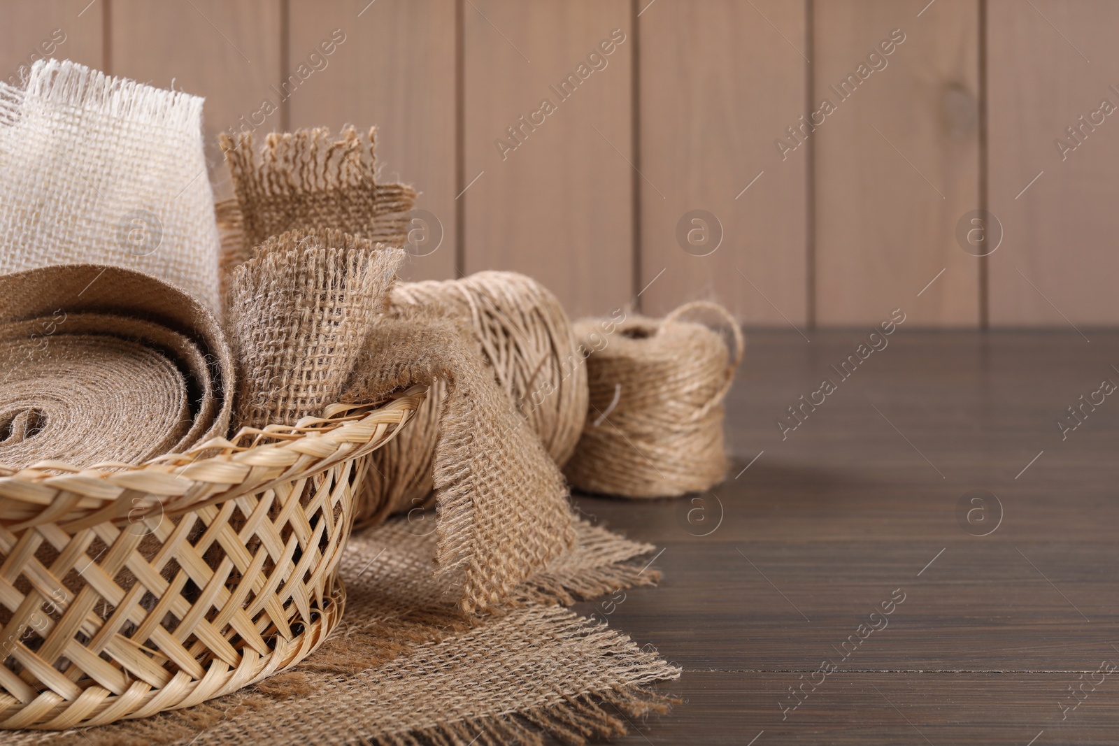 Photo of Pieces of burlap fabric and twine on table, closeup