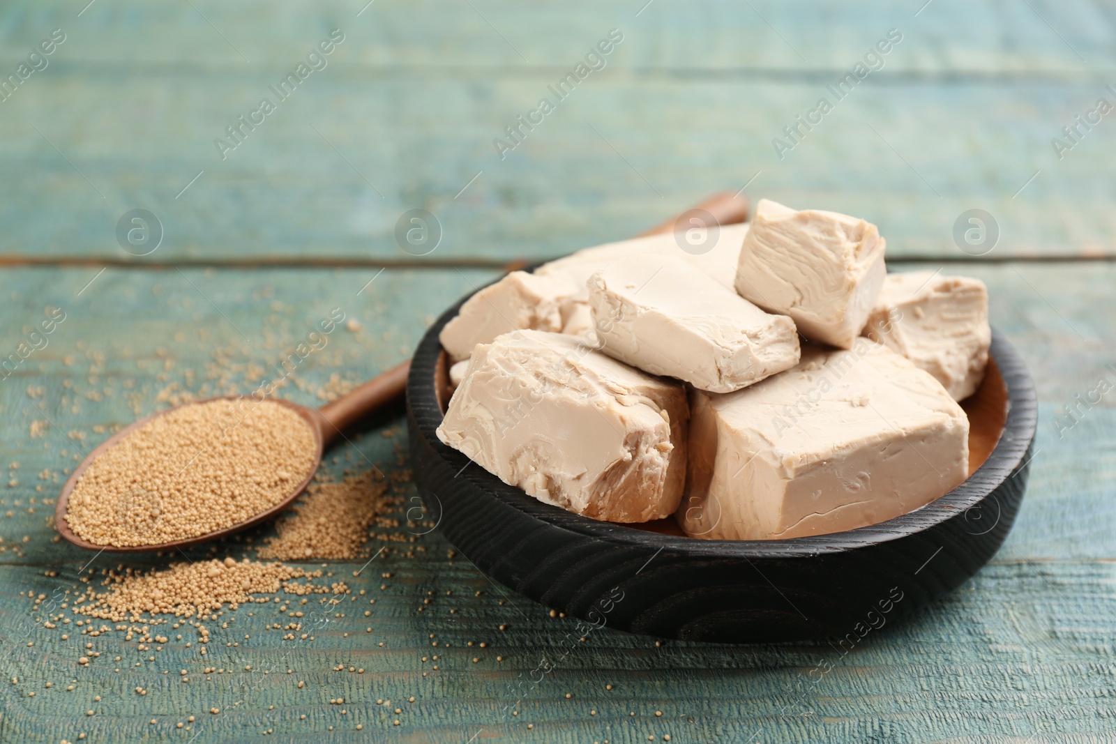 Photo of Compressed and granulated yeast on blue wooden table