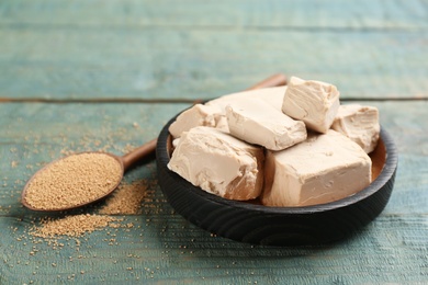 Photo of Compressed and granulated yeast on blue wooden table