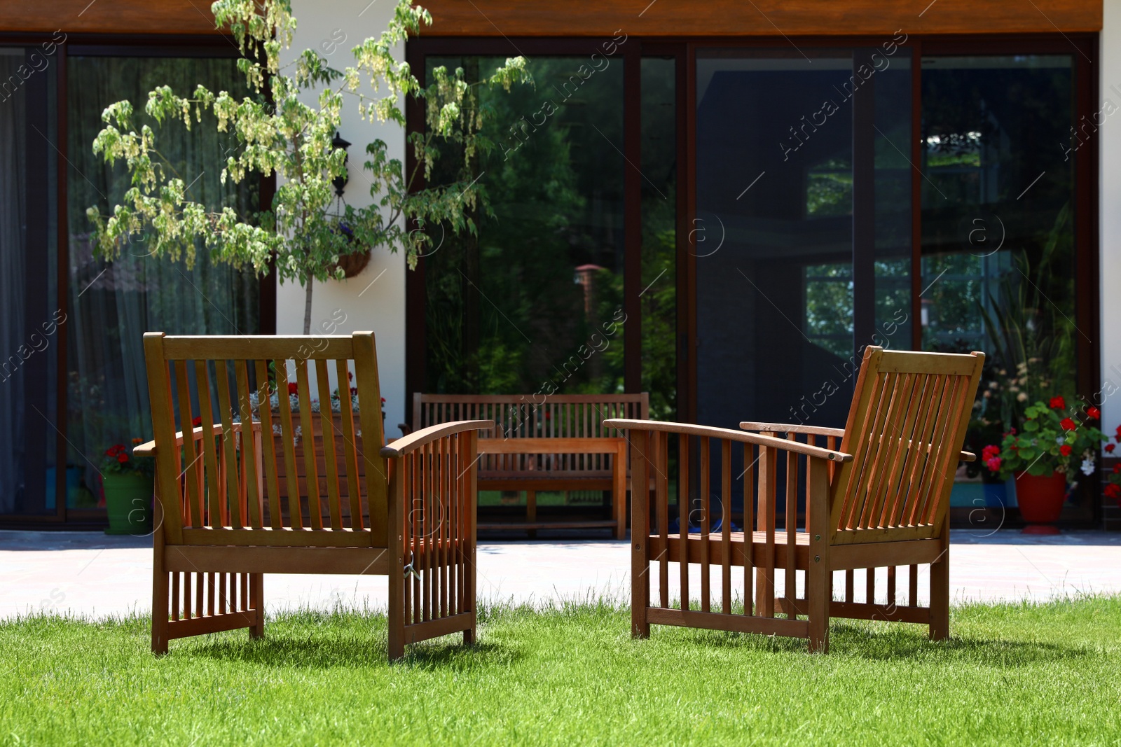 Photo of Wooden armchairs in beautiful garden on sunny day