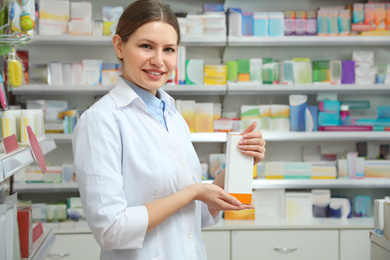Image of Professional pharmacist with medicine in modern drugstore