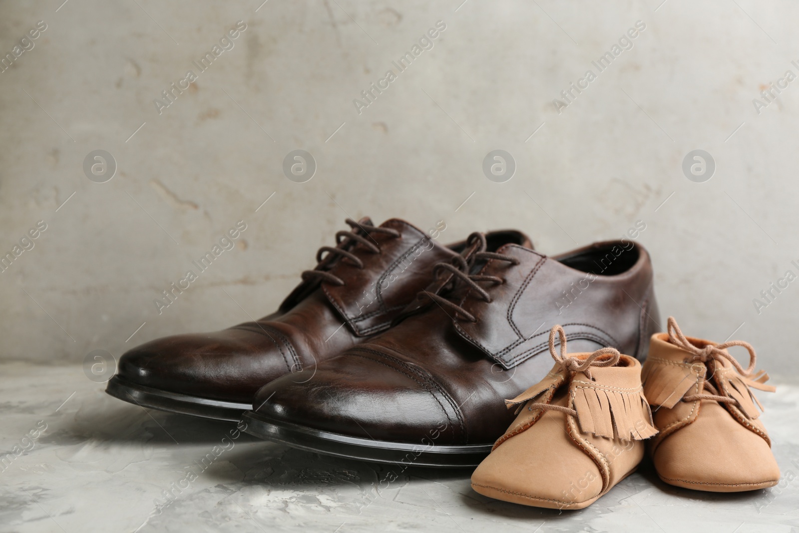 Photo of Dad and son;s shoes on grey stone background. Happy Father's Day