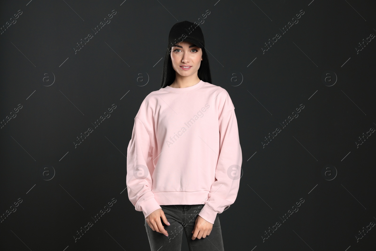 Photo of Portrait of young woman in sweater on black background. Mock up for design