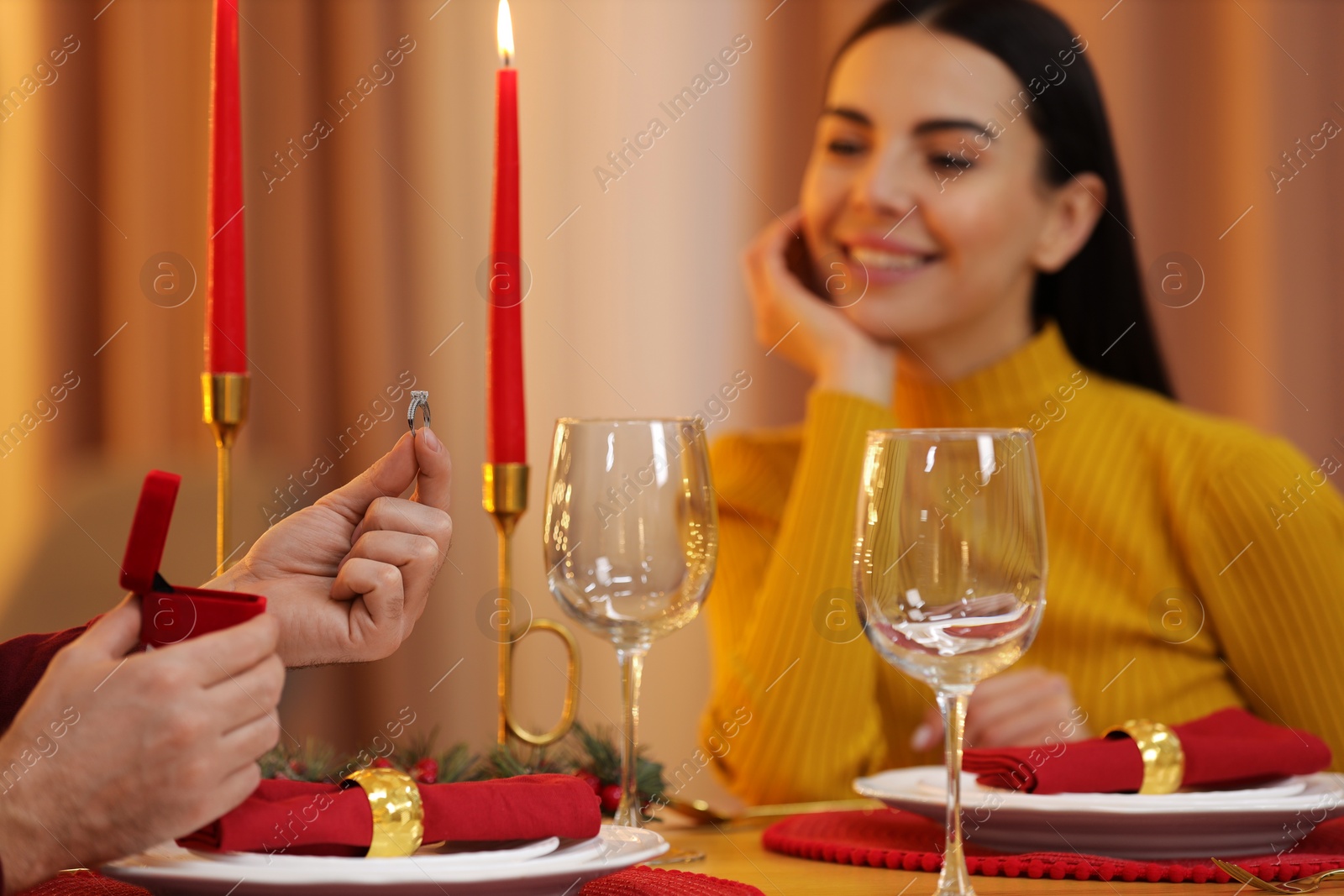 Photo of Man with engagement ring making proposal to his girlfriend at home on Christmas, selective focus