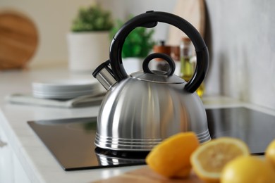 Photo of Stylish kettle with whistle on cooktop in kitchen