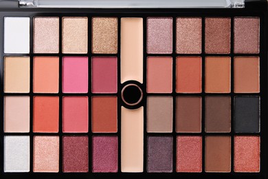 Photo of Beautiful eyeshadow palette as background, top view. Professional cosmetic product