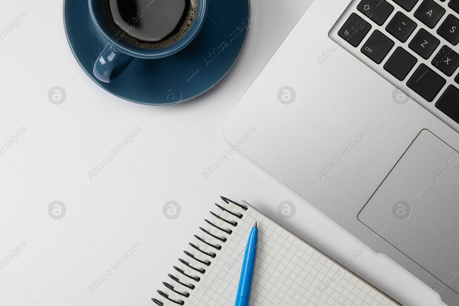 Photo of Modern laptop, notebook, pen and cup of coffee on white table, flat lay. Space for text