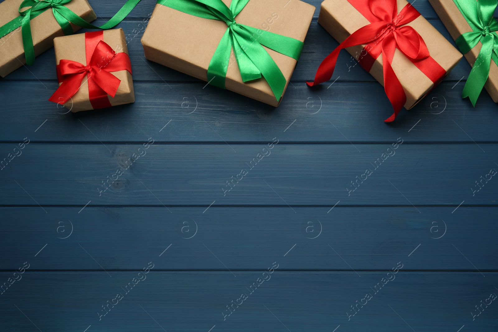 Photo of Many gift boxes on blue wooden table, flat lay. Space for text
